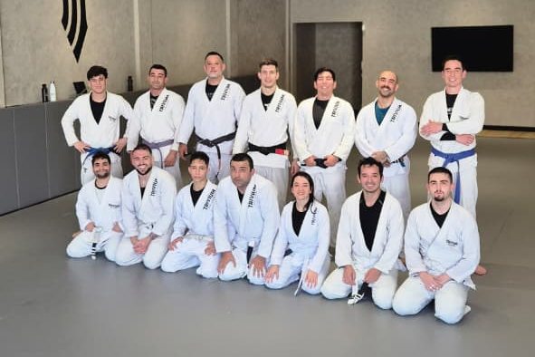 Turma adulta da Trivium reunida para foto no tatame ao final do treino
