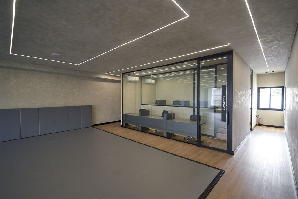 Sala de coworking envidraçada ao lado do tatame do andar superior da Trivium