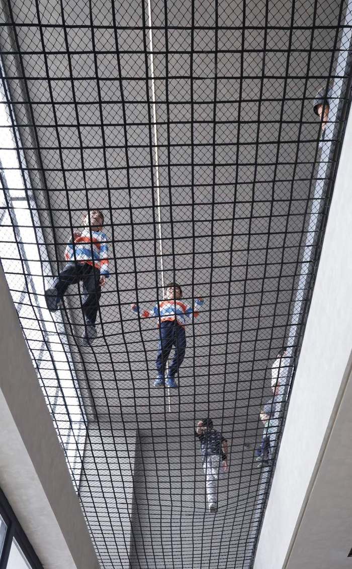 Crianças brincando no redário suspenso do andar superior da Trivium
